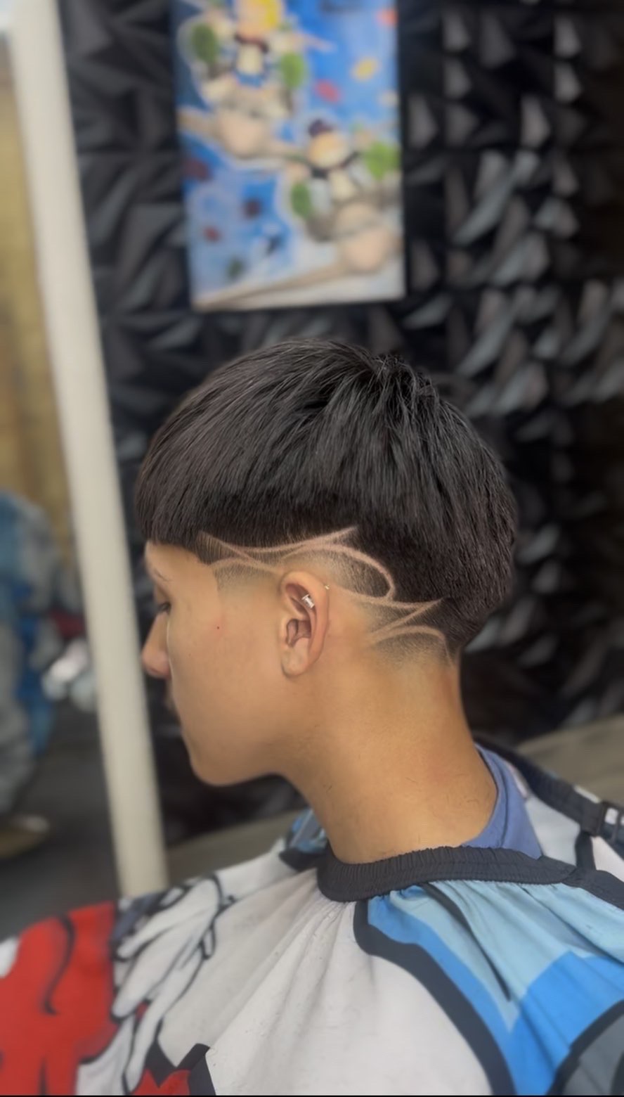 Taper fade with freestyle hair design over the ear