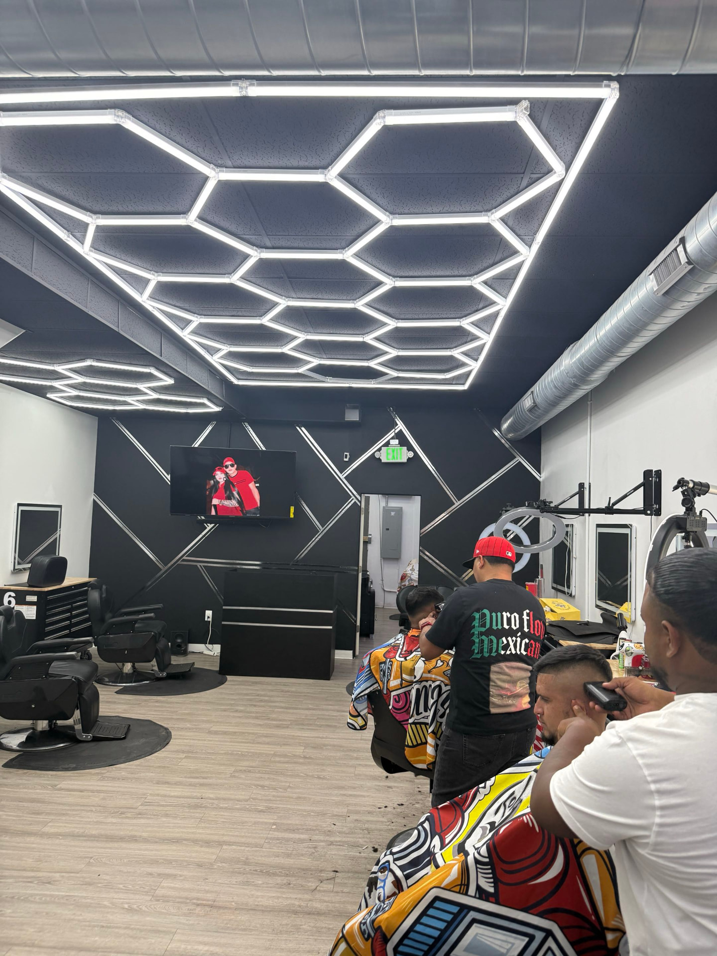 Barbers cutting hair on the floor at Don Barbas