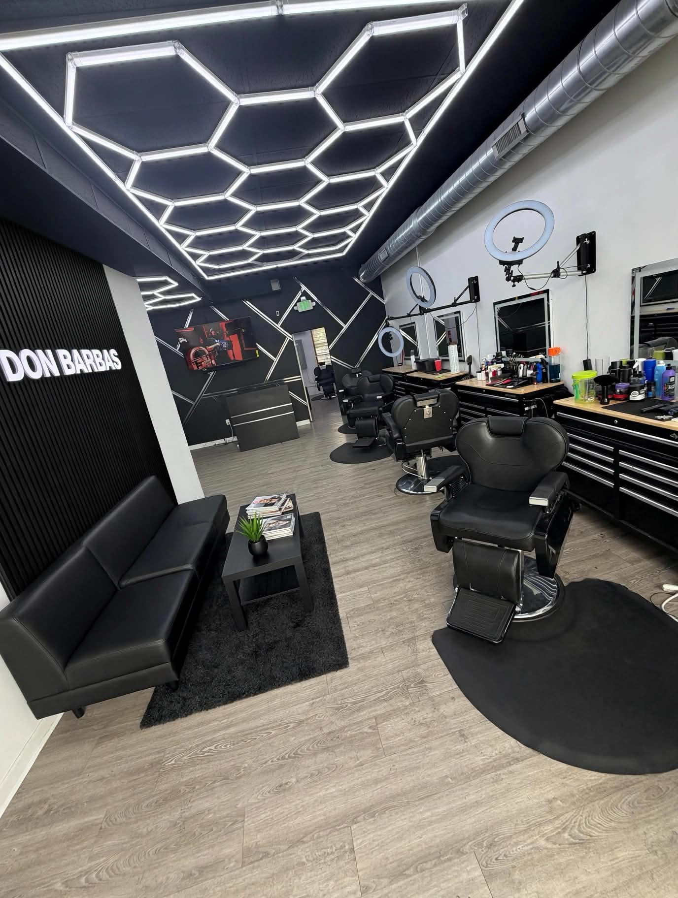 Don Barbas interior with hexagon LED lighting and barber chairs