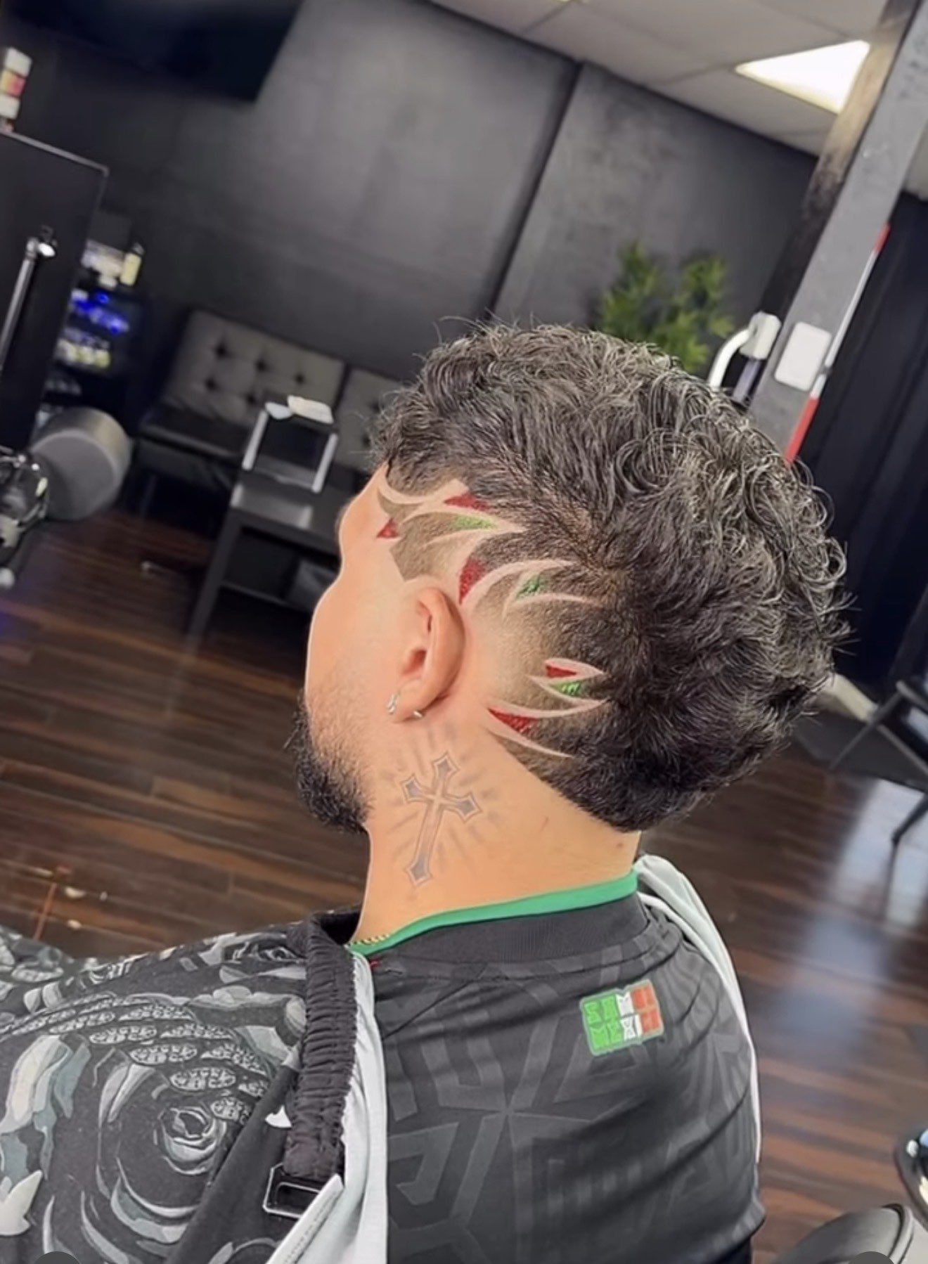 Curly taper with a freestyle Mexican flag hair design at Don Barbas